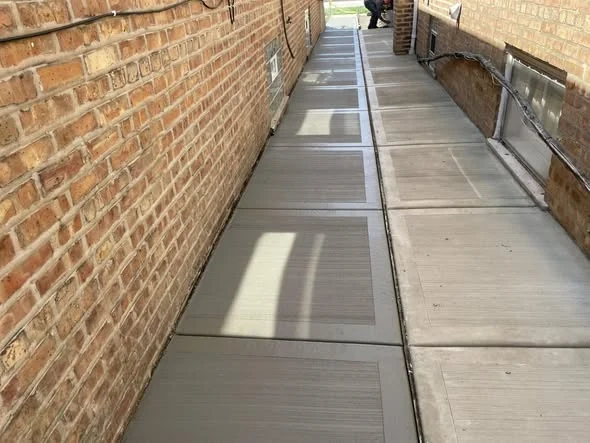 Finished side yard concrete walkway between brick walls