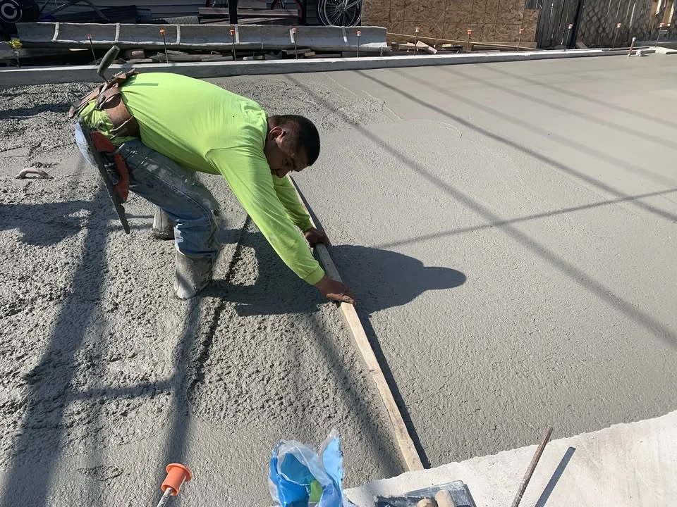 Concrete worker finishing a fresh concrete slab